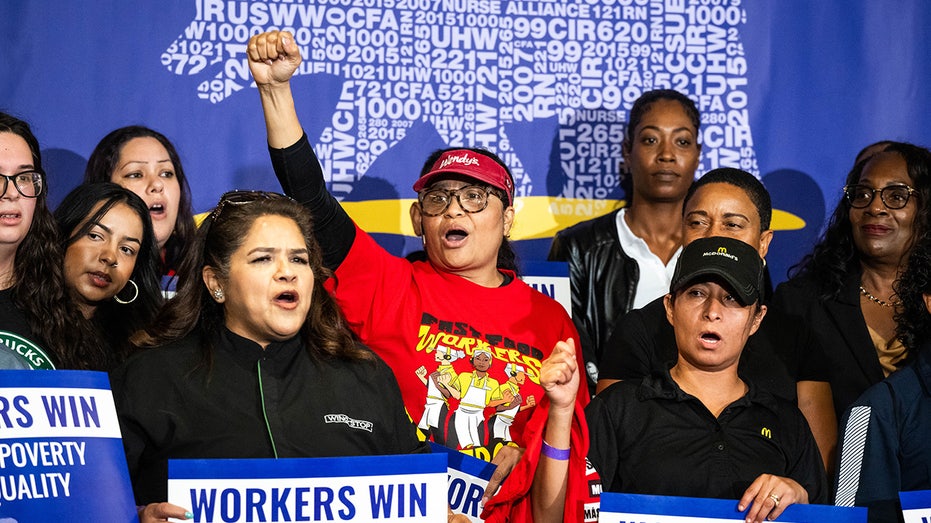 A fast-food worker cheers during the signing of a new law to raise fast-food worker's minimum wage