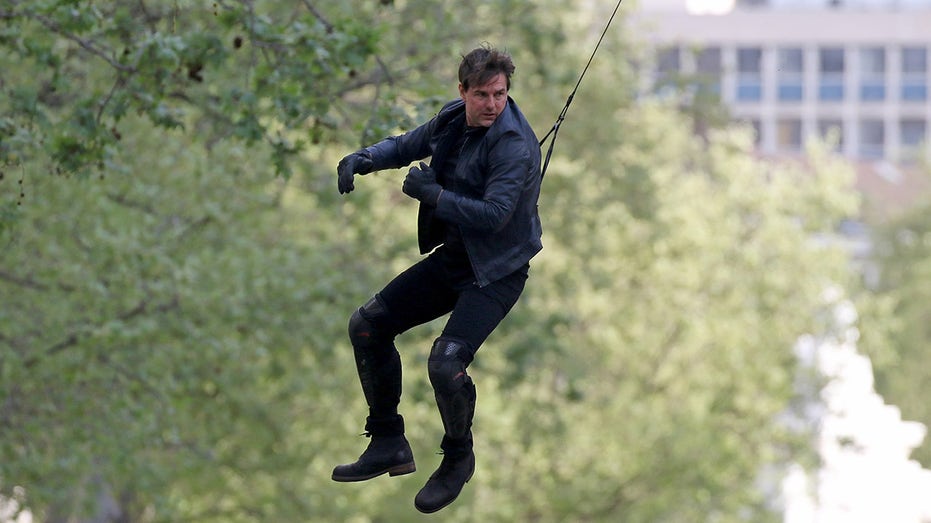 Tom Cruise hoisted above the crowd wearing black leather jacket