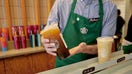 A barista places an iced coffee in the mobile pickup area at a Starbucks location in New York on Aug. 17, 2023. 