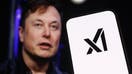 In this photo illustration, logo of &apos;xAI&apos; is displayed on a mobile phone screen in front of Elon Musk&apos;s photo in Ankara, Turkiye on July 13, 2023. 