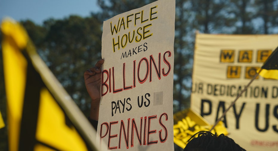 Sign reading, "Waffle House makes billions, pay us pennies"