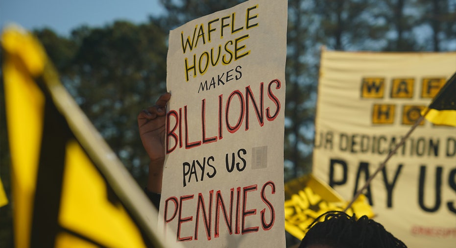 Sign reading, "Waffle House makes billions, pay us pennies"