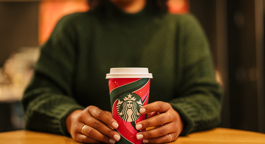 woman holds starbucks holiday cup