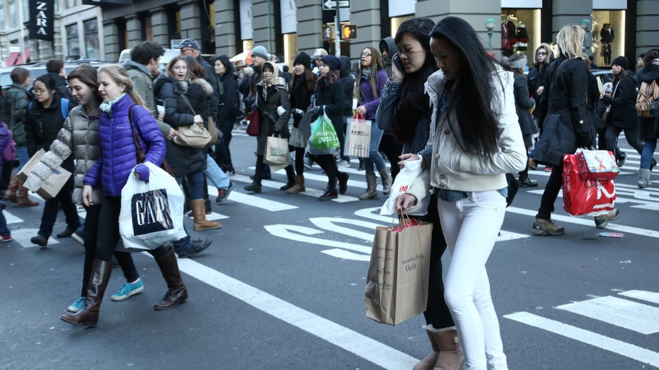 people walking to stores, holding shopping bags