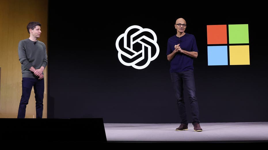 Satya Nadella speaks as Sam Altman looks on