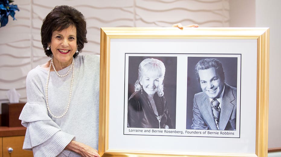 Jewelry store co-owner Madalyn Rovinsky, holding photo of her parents