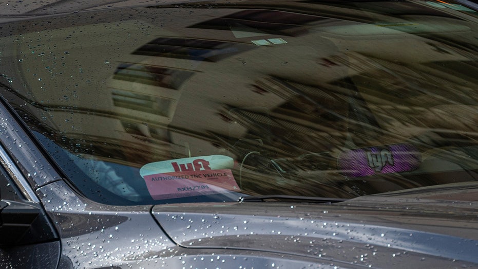 A Lyft vehicles windshield with Lyft sticker
