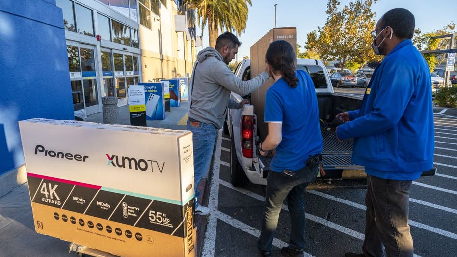 Best Buy workers helping customer