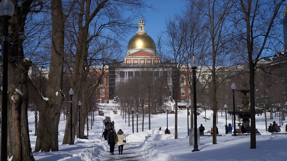 Massachusetts capitol with people walking by in the snow