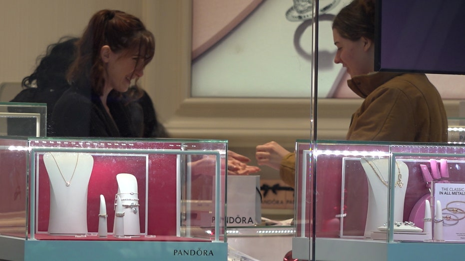 At the Mall of America, a woman talks with a sales associate at Pandora.