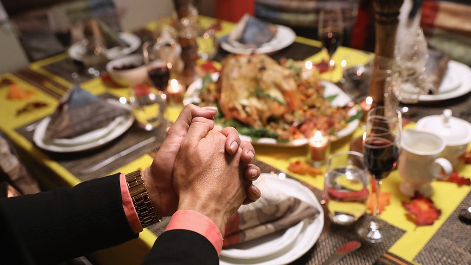 A family prays before the Thanksgiving meal