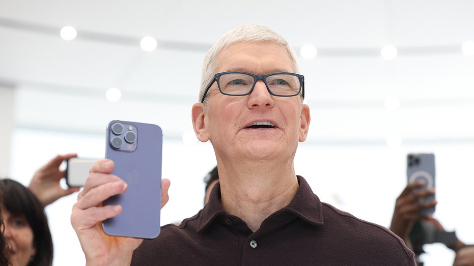Tim Cook holding an iPhone