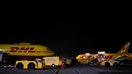 Cargo planes are unloaded during the overnight sort at the DHL Worldwide Express hub of Cincinnati/Northern Kentucky International Airport in Hebron, Kentucky, U.S., on Friday, August 1, 2014. Three of the biggest delivery companies, including DHL Worldwide Express, have released environmental data that show their overall emissions of global warming gases are declining slightly. Photographer: Luke Sharrett/Bloomberg via Getty Images

