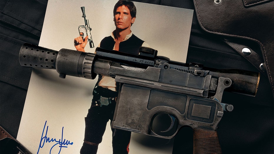 Han Solo's blaster on an autographed photo of Han solo