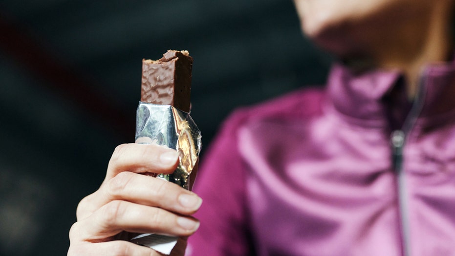 woman holds protein bar