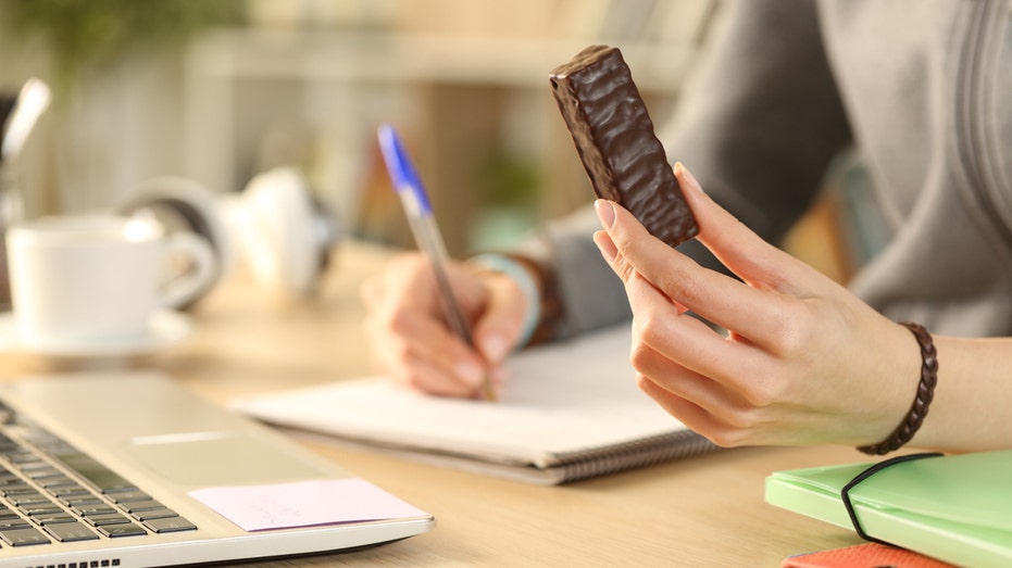 woman holds chocolate protein bar