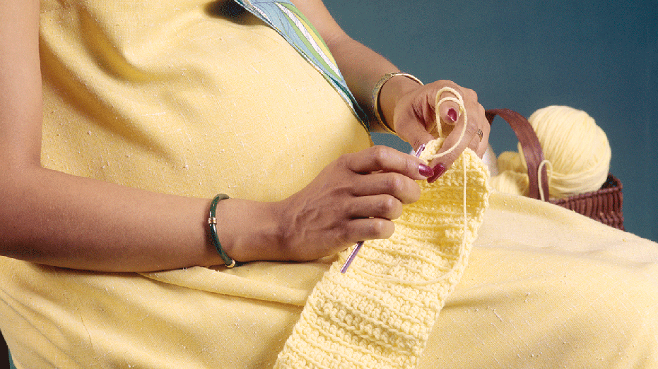 A pregnant woman knitting