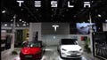 A staff member looks at Tesla's new Model 3 sedan displayed next to Model X SUV at the China International Fair for Trade in Services (CIFTIS) in Beijing, China September 2, 2023. REUTERS/Florence Lo

