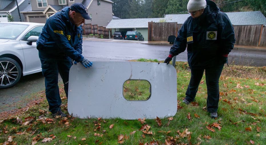 Two investigators examine a plane door