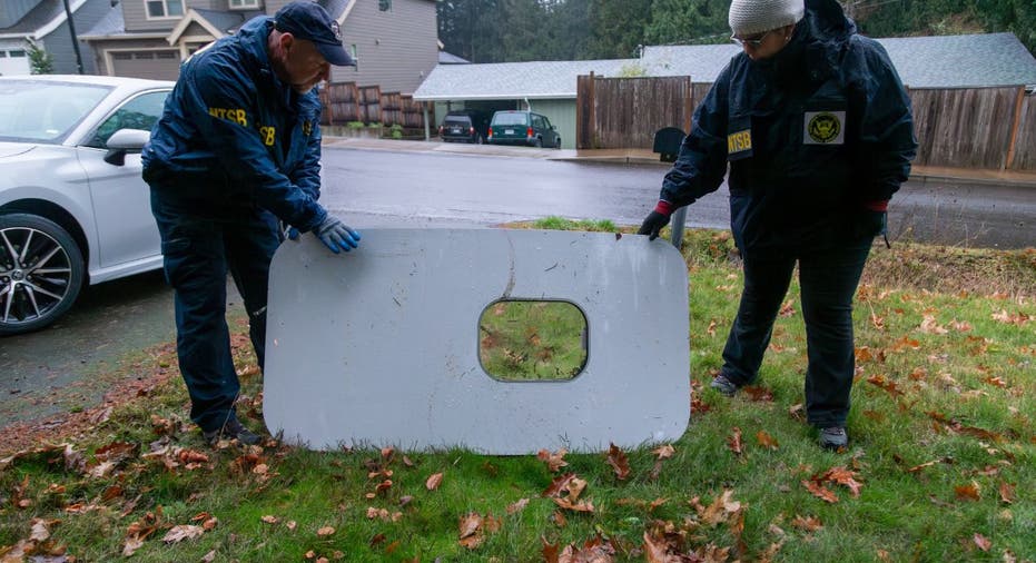 Two investigators examine a plane door