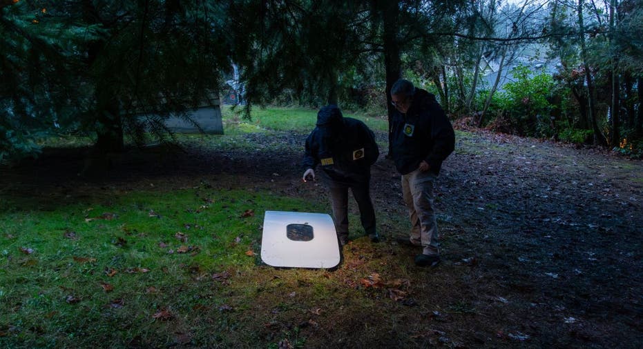 Two investigators examine a plane door