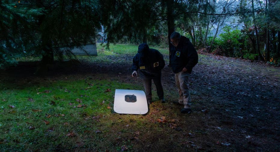 Two investigators examine a plane door