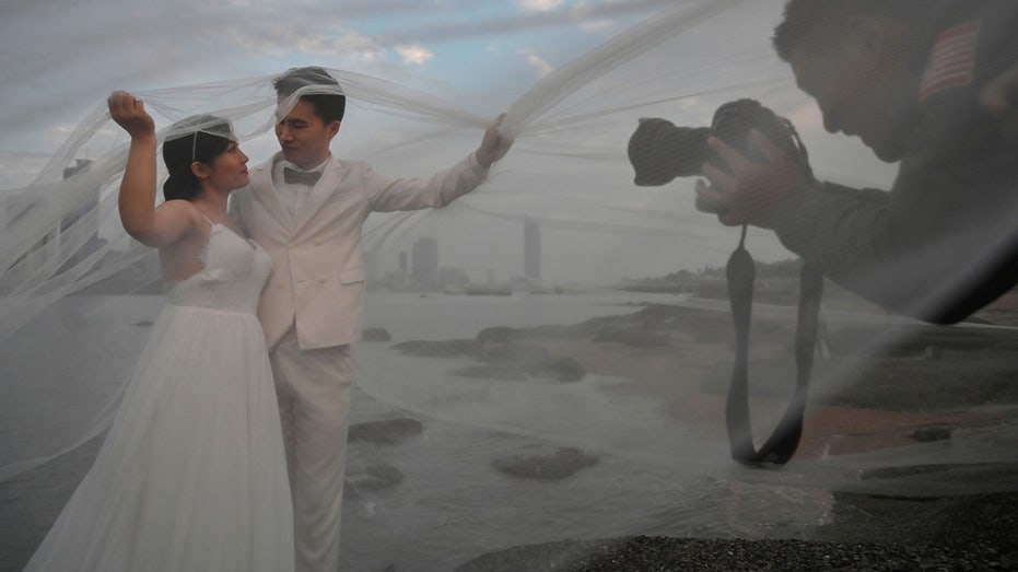 A couple poses for a wedding photographer