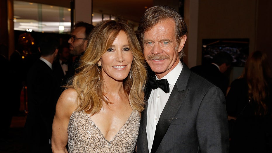 William H. Macy in a suit and tie next to Felicity Huffman in a sparkly dress