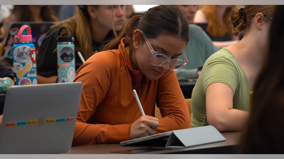 Student taking notes in class at Pepperdine University