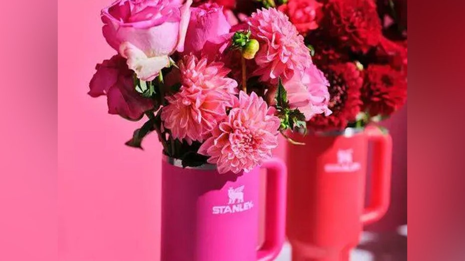 Stanley cups with red and pink flowers in them