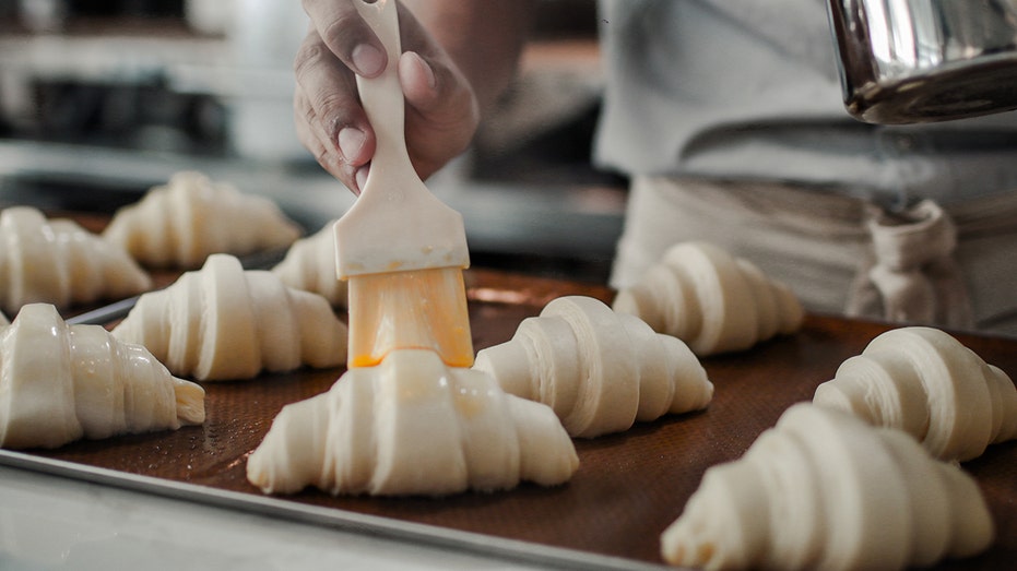 brushing freshly proofed croissant