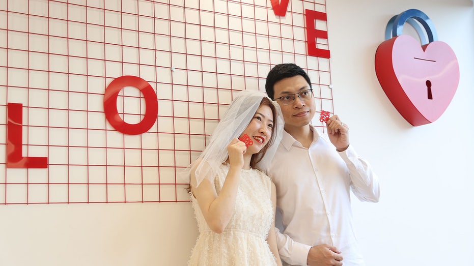 A newly-wed couple pose for a photo