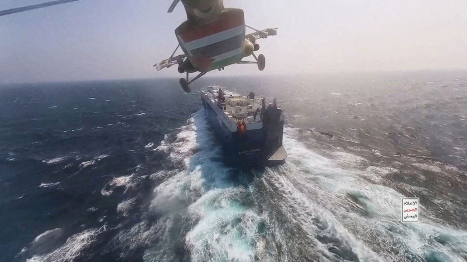 Houthi military helicopter flies over the Galaxy Leader cargo ship in the Red Sea