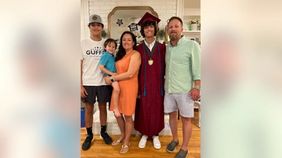 Brandon Guffey (right) pictured with his family, including Gavin Guffey (second from right) in his graduation gown