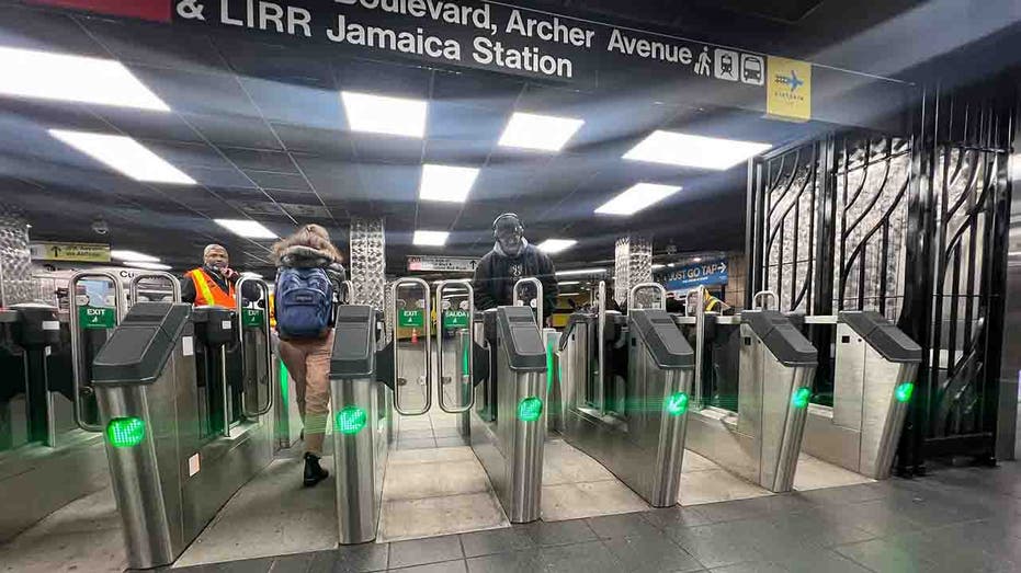 customers paying fares at subway gate