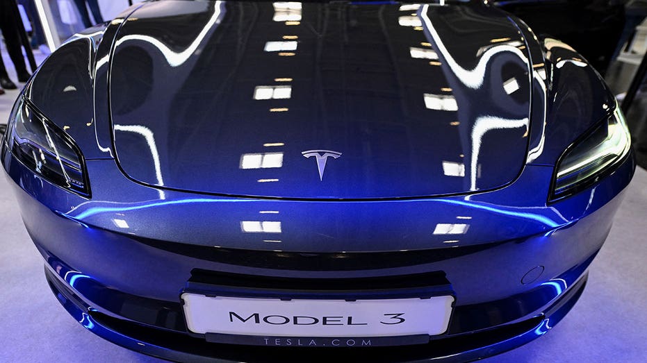 A blue Tesla Model 3 on display