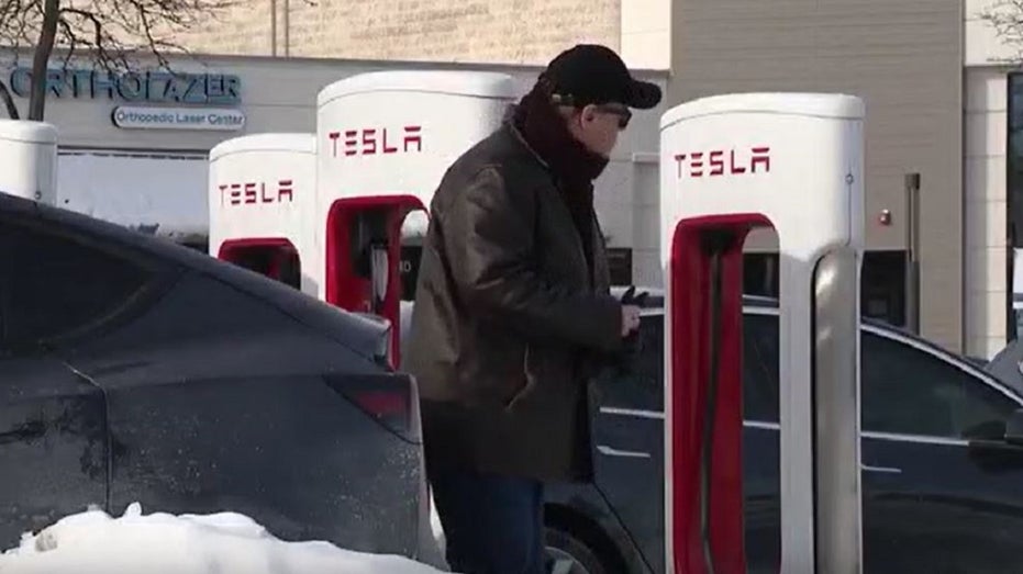 A man at a Tesla charging station in Illinois