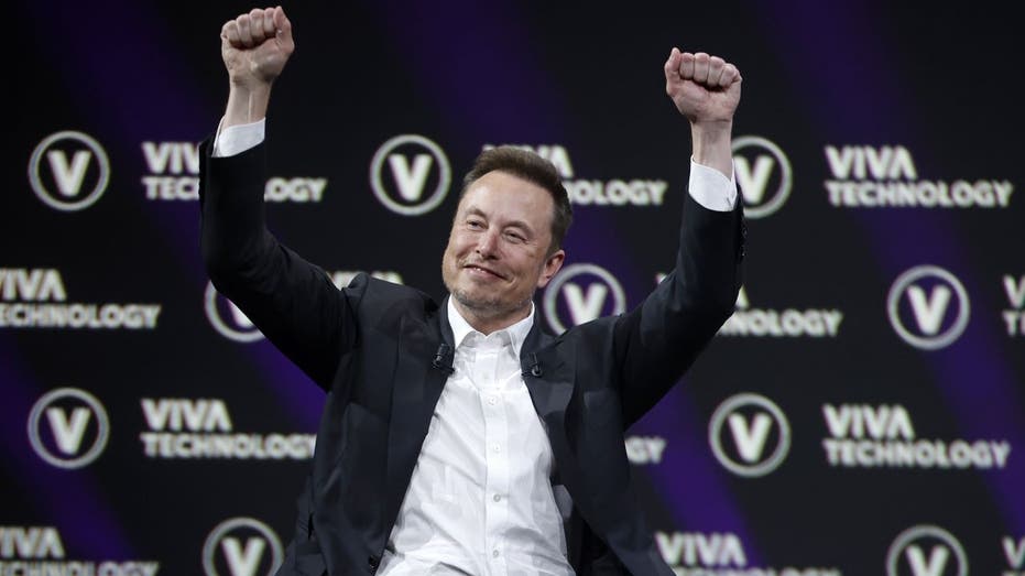 Elon Musk with hands in the air
