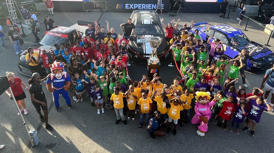 Matt Kaulig and Speediatrics kids pose in front of racecars