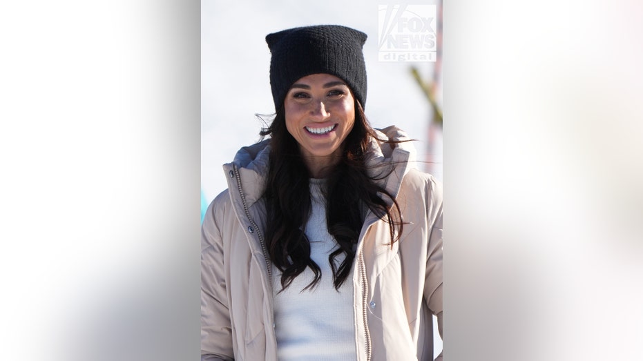 Meghan Markle smiling with a beanie on