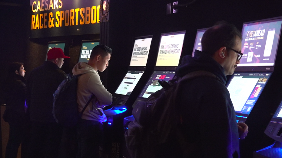 Bettors at the kiosk machines at Caesars Sportsbook