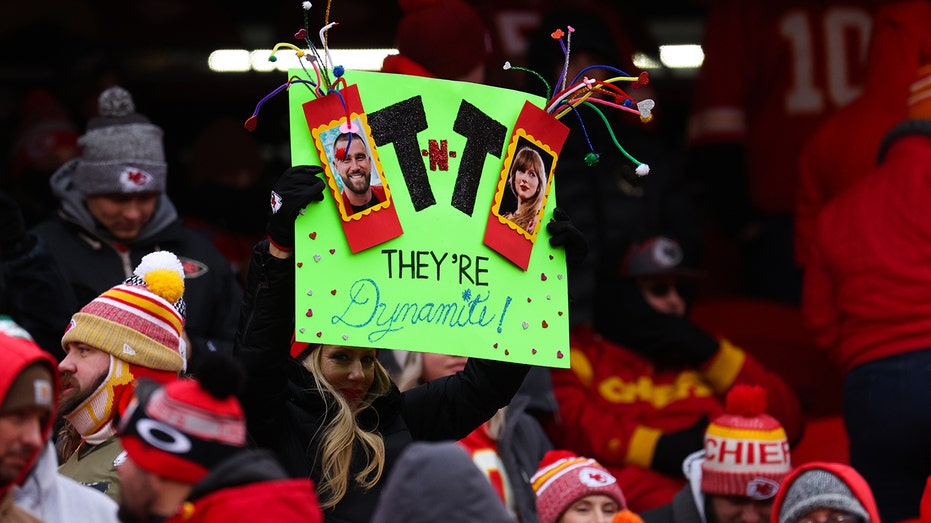 Fans hold up a sign for Travis and Taylor Swift at a Chiefs game