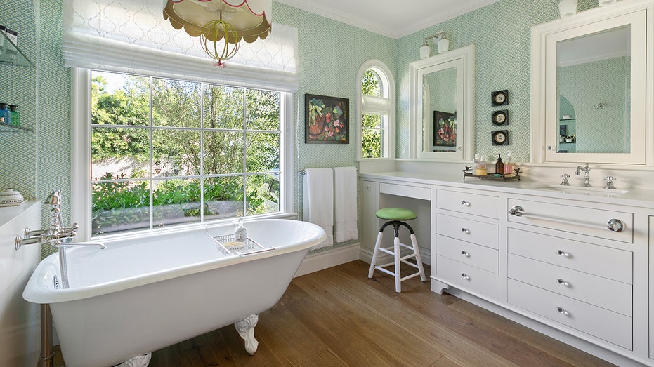 A bathroom, featuring a vintage tub and a vanity.