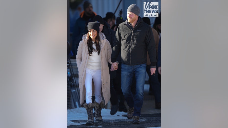 Harry and Meghan hold hands as they're walking