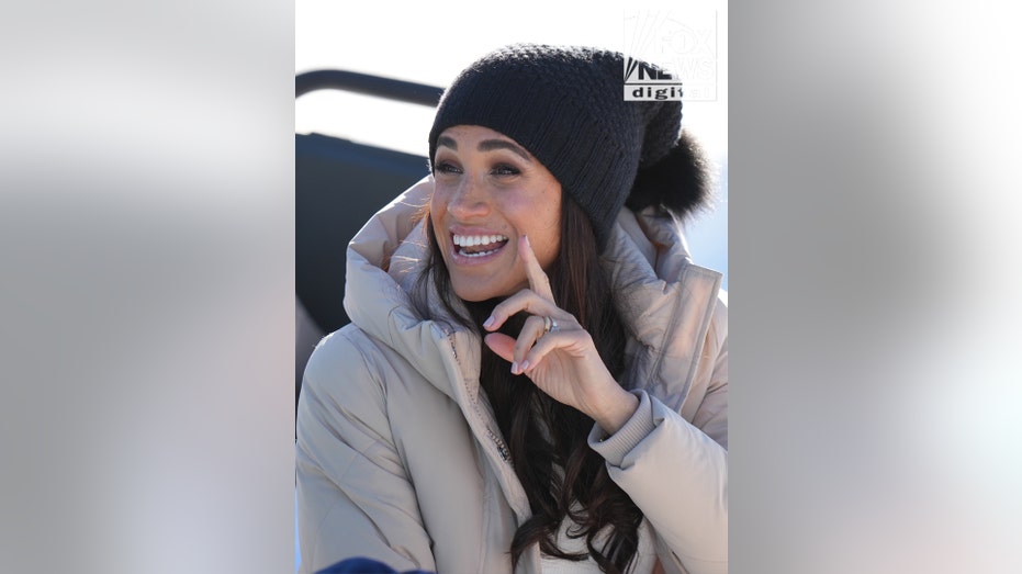 Meghan Markle smiling and pointing