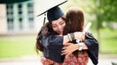 Female college student hugging her mother on graduation date