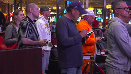 Men in line to cash in or place their bets.