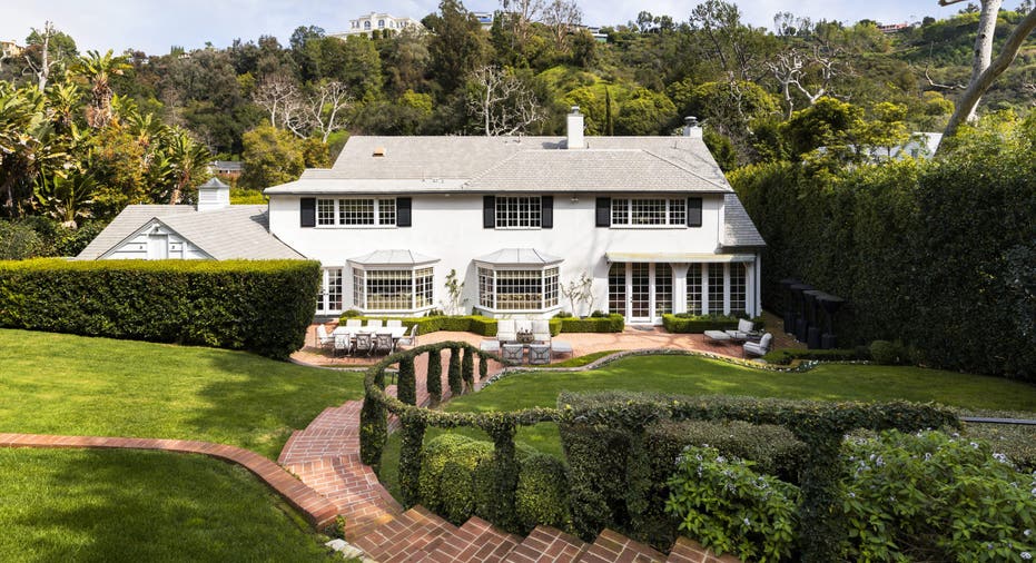 A brick staircase behind the white home surrounded by grass