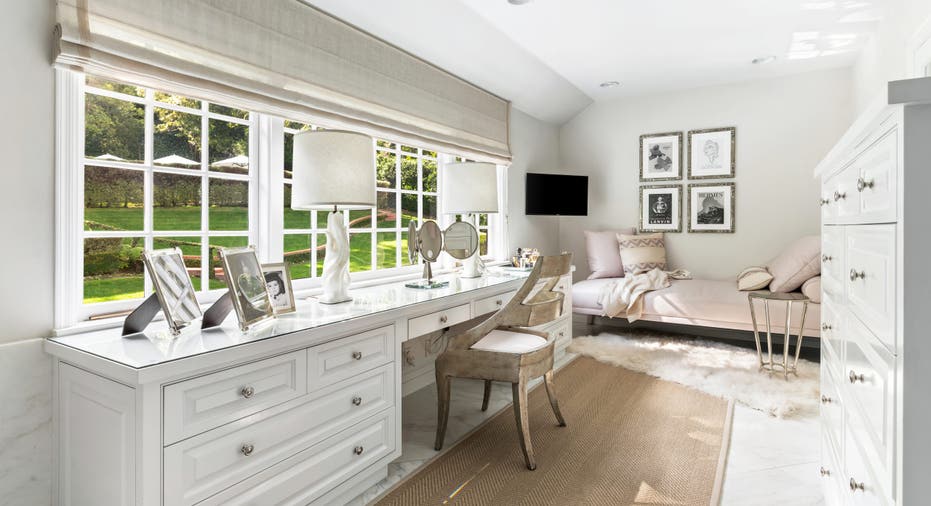 Large vanity with one chair and light pink chaise lounge in this bathroom