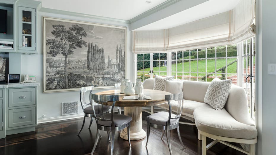 Seating area in kitchen with a curved sofa as a dining nook in front of a picture window